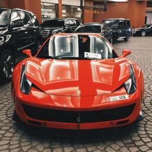 Red Ferrari sports car showcased at Dubai Mall, UAE, symbolizing luxury and elegance.